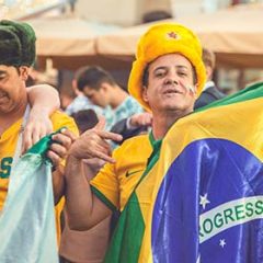 2 men dressed in Brazil clothes with Brazil flag